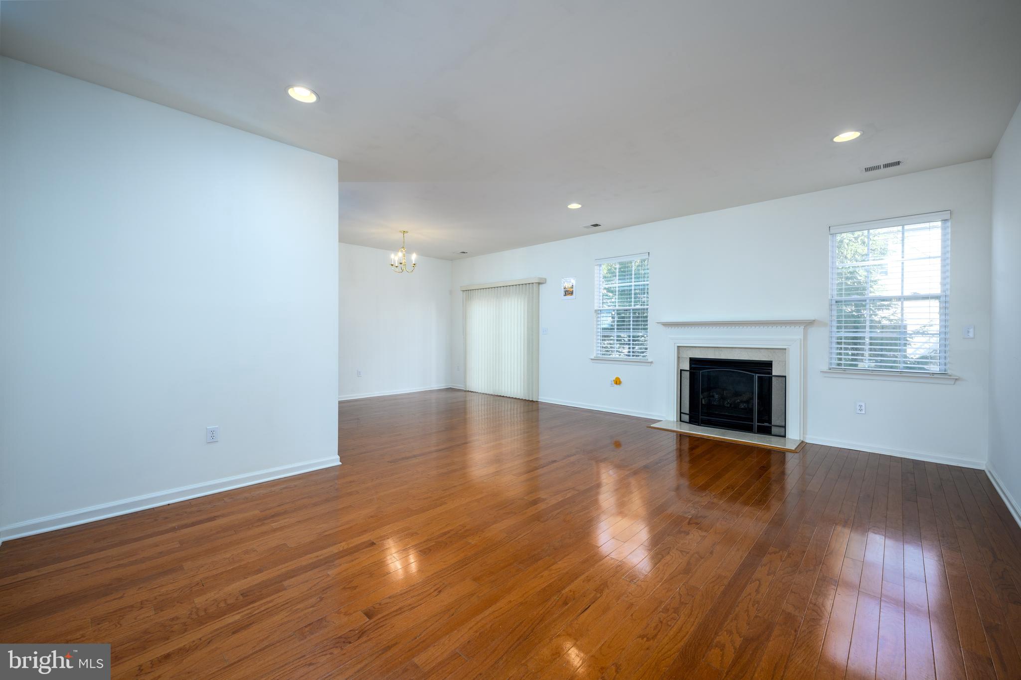 249 Concord Place Pennington, NJ 08534 - Photo 5 of 22 an empty room with wooden floor and fireplace