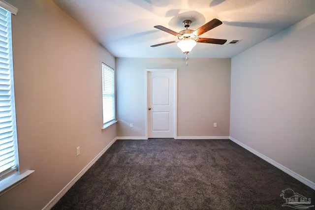 an empty room with a window and a fan