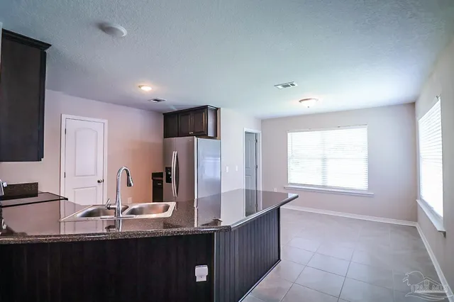 a kitchen with stainless steel appliances granite countertop a sink and a refrigerator