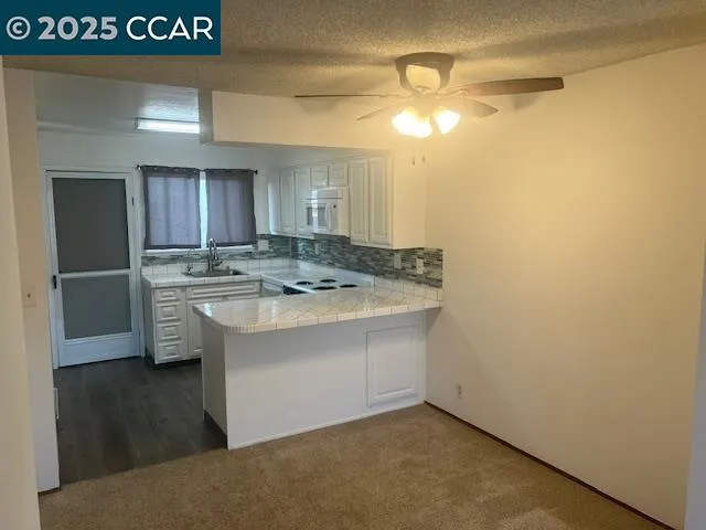 a kitchen with a sink a stove and cabinets