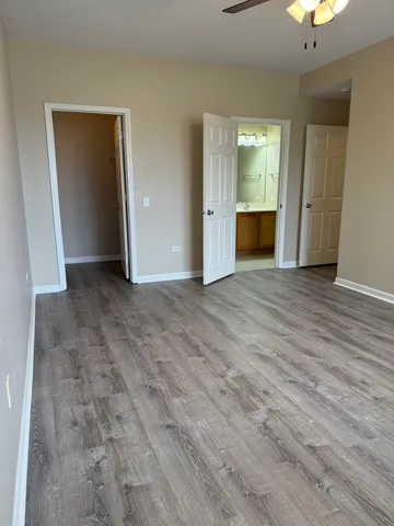 a view of an empty room with wooden floor and a cabinet