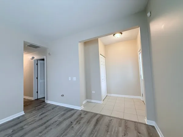 an empty room with wooden floor and mirror