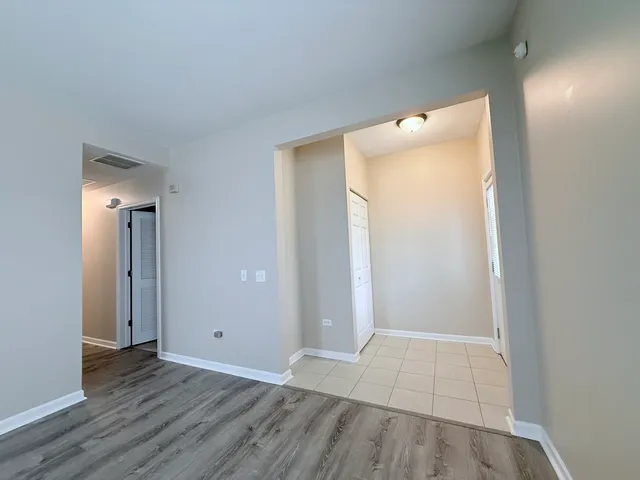 an empty room with wooden floor and mirror