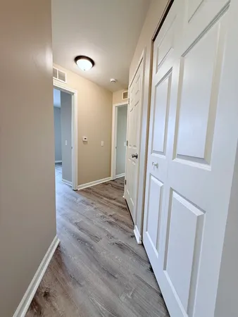 a view of a hallway with wooden floor and staircase