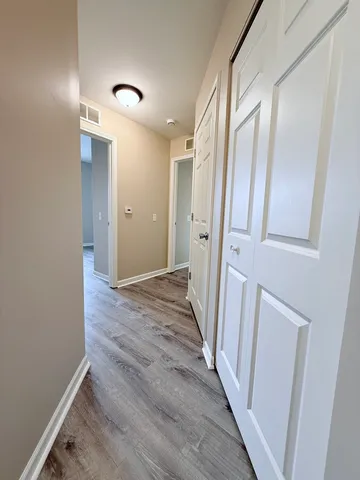 a view of a hallway with wooden floor and staircase