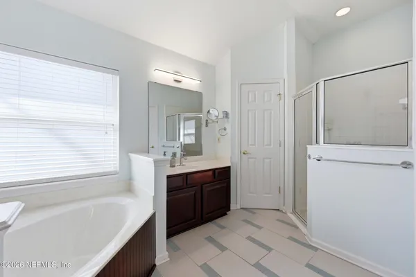 a bathroom with a tub sink and mirror