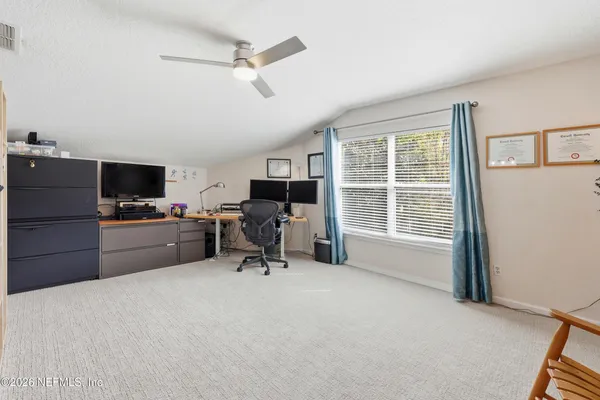 a view of a livingroom with workspace and a window