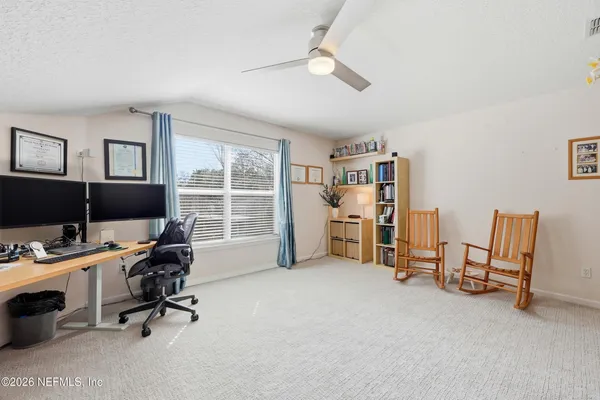 a view of a workspace with furniture and a window