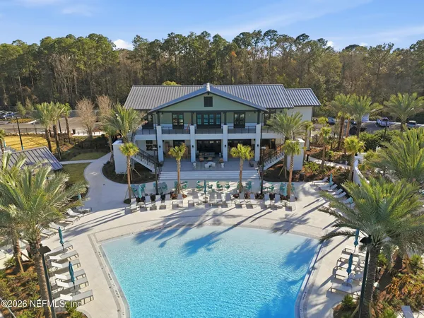 an aerial view of a house with swimming pool and furniture