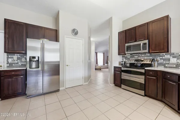 a kitchen with stainless steel appliances granite countertop a refrigerator and a stove top oven