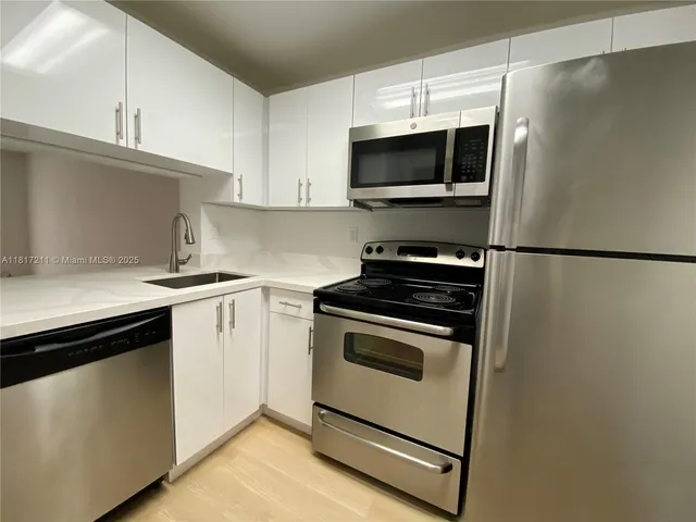 a kitchen with stainless steel appliances a stove a microwave and a sink