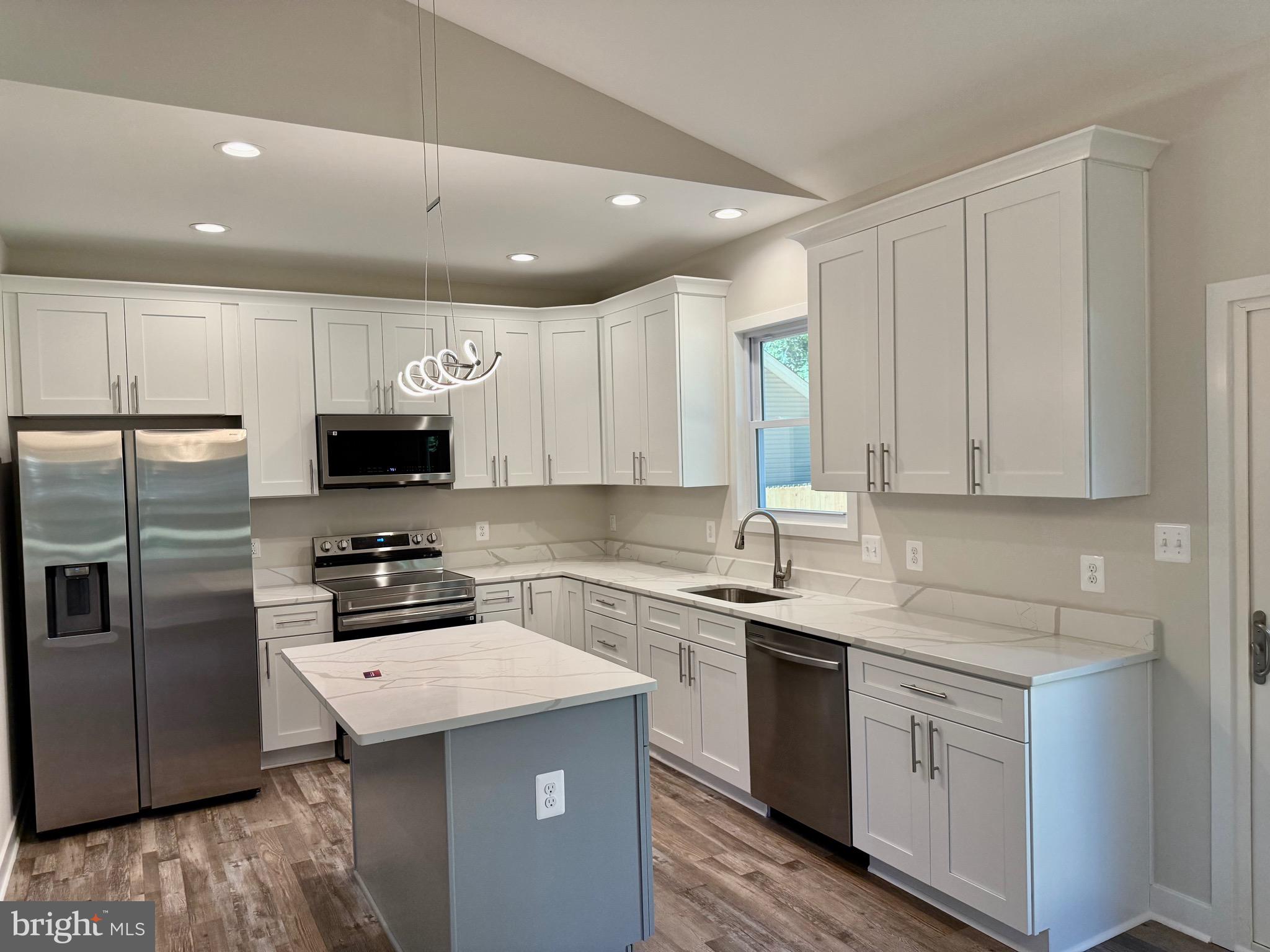 228 Dale Drive Colonial Beach, VA 22443 - Photo 13 of 59 a kitchen with white cabinets sink and stainless steel appliances