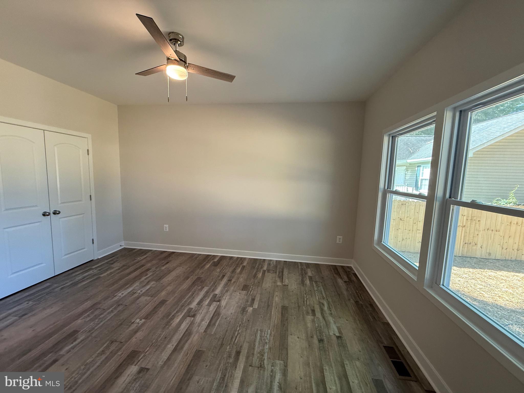 228 Dale Drive Colonial Beach, VA 22443 - Photo 16 of 59 an empty room with wooden floor fan and windows