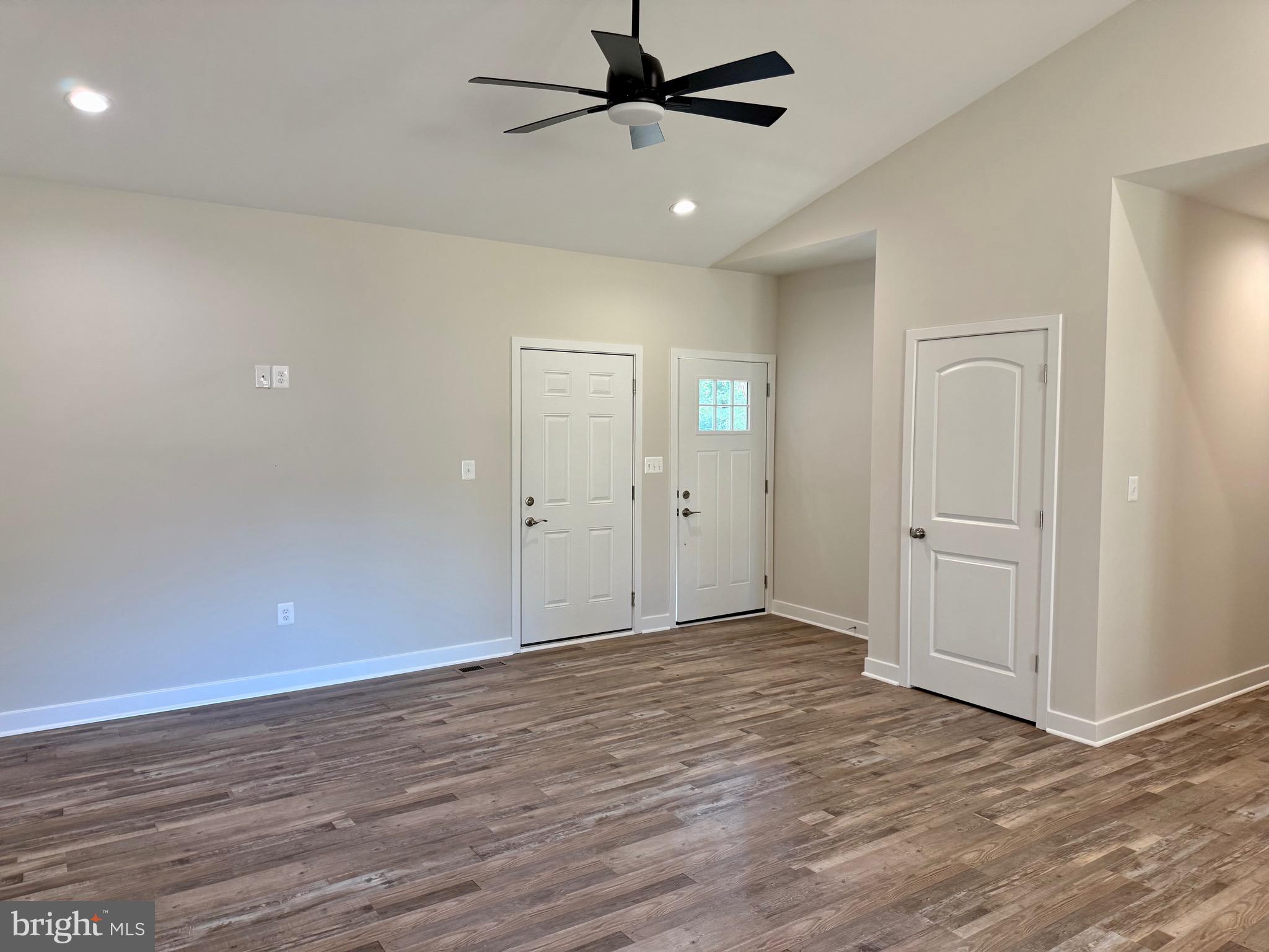 228 Dale Drive Colonial Beach, VA 22443 - Photo 6 of 59 an empty room with wooden floor a ceiling fan and windows