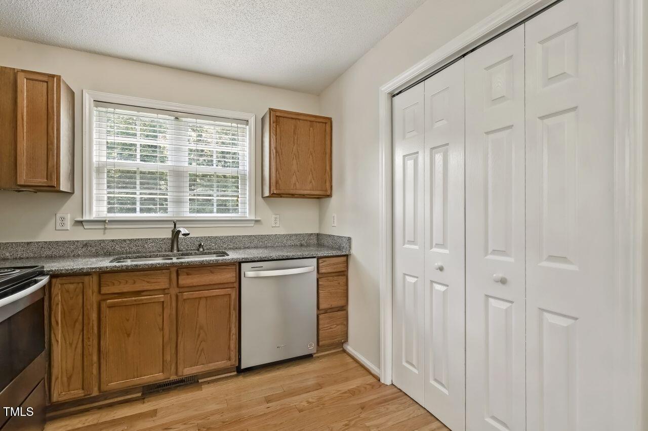 100 Bryant Drive Smithfield, NC 27577 - Photo 15 of 34 a kitchen with stainless steel appliances granite countertop a stove a sink and white cabinets with wooden floor