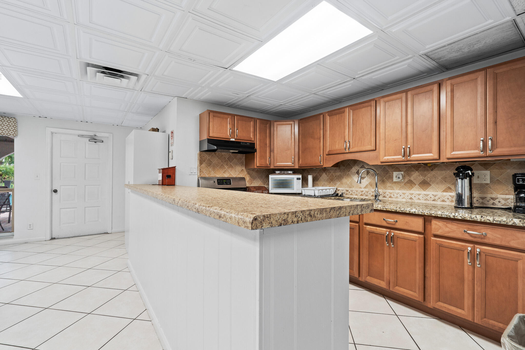 250 Northeast 20th Street, Unit 1290 Boca Raton, FL 33431 - Photo 32 of 41 a kitchen with granite countertop a sink and a stove top oven