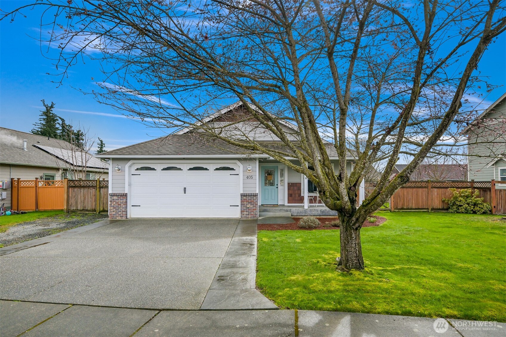 a front view of a house with yard and tree