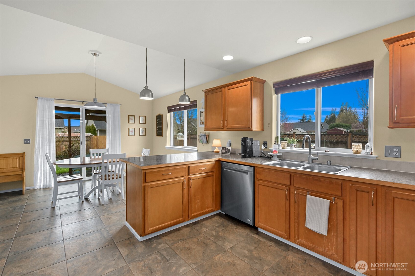405 Jackson Court Nooksack, WA 98276 - Photo 8 of 28 a large kitchen with kitchen island granite countertop wooden cabinets a dining table and chairs