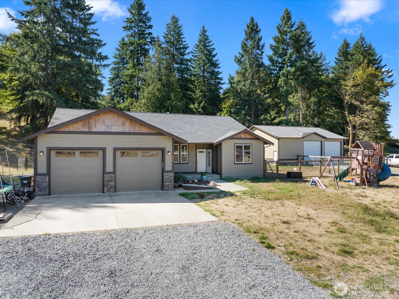 606 288th Street East Roy, WA 98580 - Photo 1 of 37 a front view of a house with a yard and garage