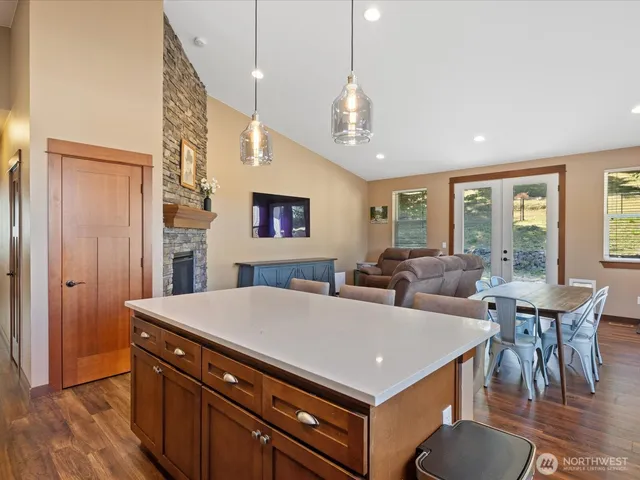 a living room with furniture a large window and wooden floor