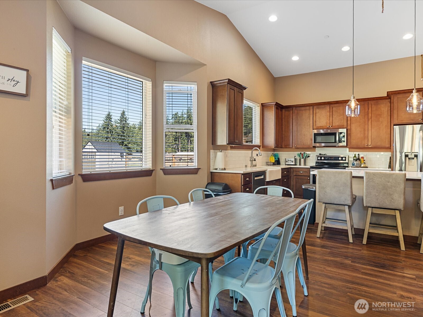 606 288th Street East Roy, WA 98580 - Photo 13 of 37 a kitchen with stainless steel appliances granite countertop a stove a refrigerator a kitchen island with a dining table and chairs