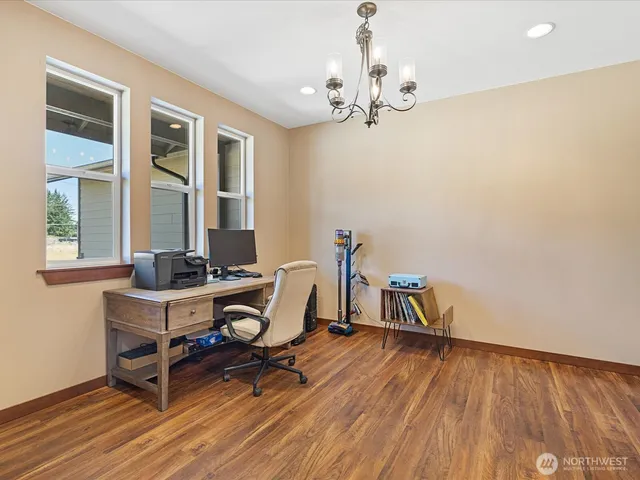 a view of a workspace with furniture and wooden floor