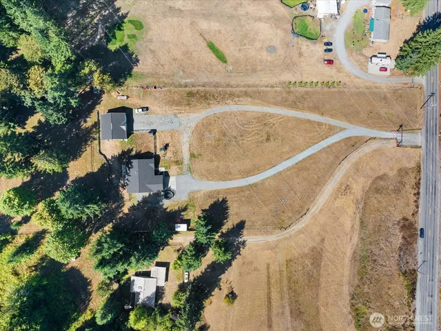 an aerial view of a house with a yard and a large tree