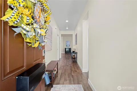 a view of a hallway with wooden floor and a potted plant