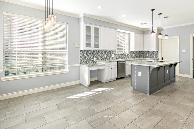 a kitchen with kitchen island granite countertop a stove a sink and a refrigerator