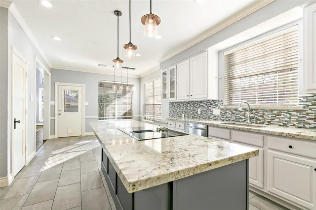 a kitchen with granite countertop a sink and a refrigerator