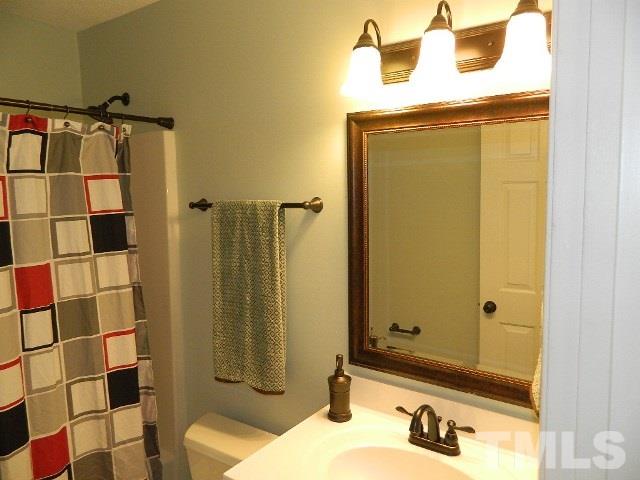 5822 Finestra Way Raleigh, NC 27610 - Photo 14 of 25 a bathroom with a sink and a mirror