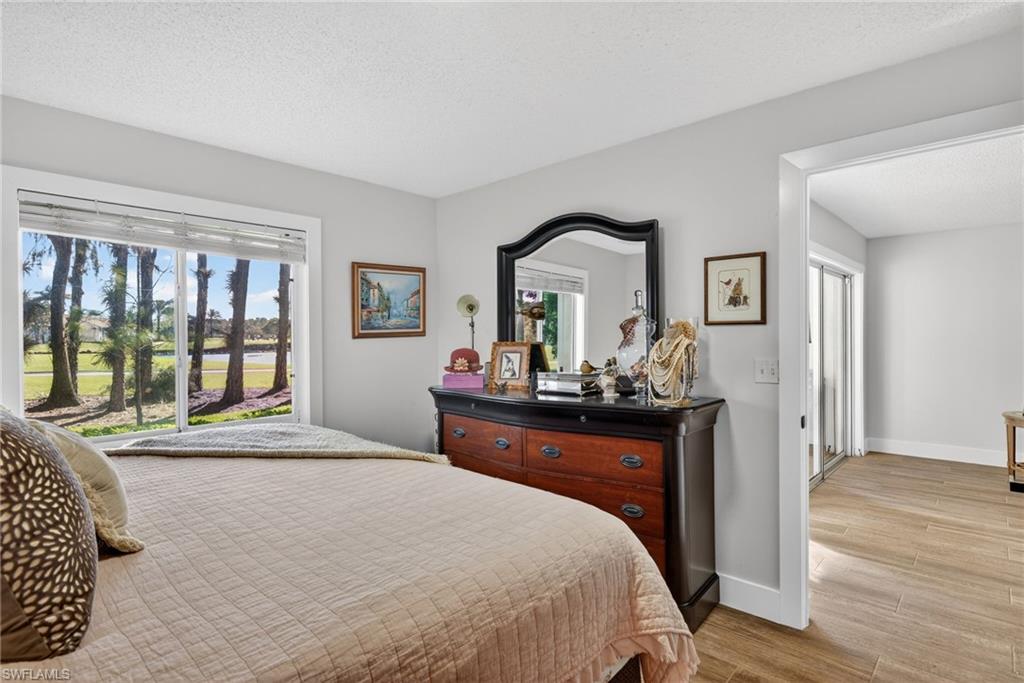 3665 Amberly Circle, Unit B101 Naples, FL 34112 - Photo 12 of 30 a bed room with a bed mirror and a window