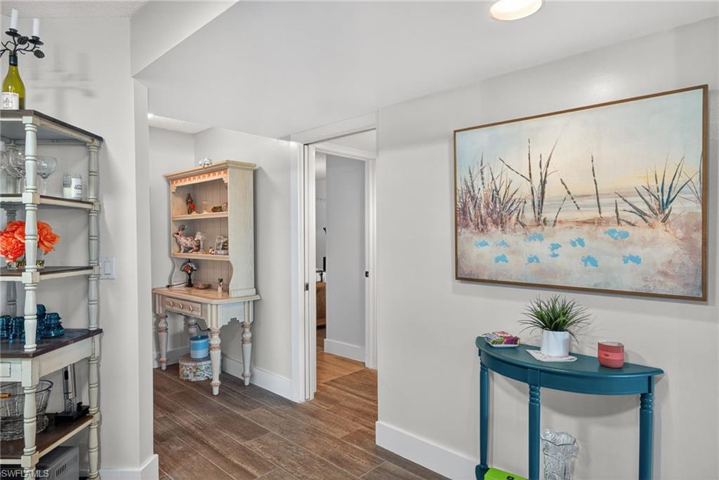 3665 Amberly Circle, Unit B101 Naples, FL 34112 - Photo 2 of 30 a view of a hallway with workspace and wooden floor