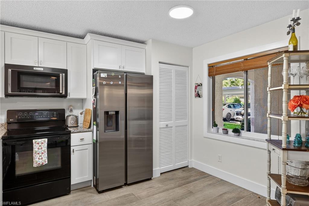 3665 Amberly Circle, Unit B101 Naples, FL 34112 - Photo 5 of 30 a kitchen with a refrigerator stove and microwave