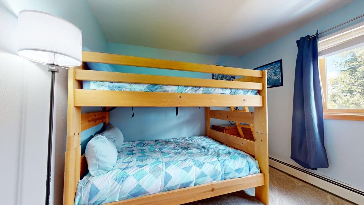 91200 Ryan Gulch Road, Unit 213 Silverthorne, CO 80498 - Photo 23 of 33 a bedroom with a bed and a window