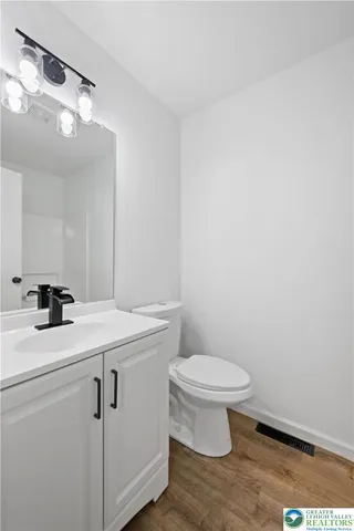 a bathroom with a sink a toilet and a mirror