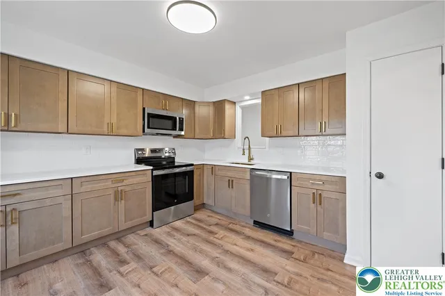 a kitchen with a sink cabinets and stainless steel appliances