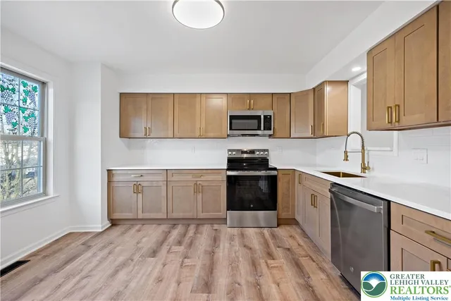 a kitchen with a sink a window and stainless steel appliances