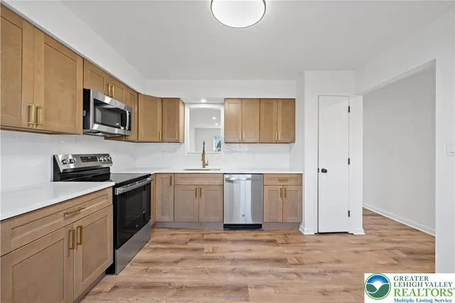 a kitchen with stainless steel appliances granite countertop a stove a sink and a microwave