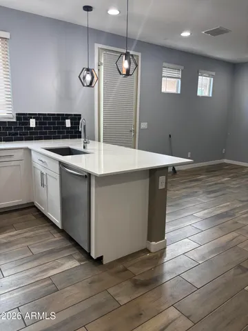 a kitchen with a sink cabinets and wooden floor