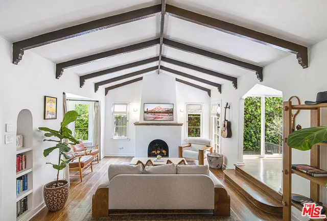 a living room with fireplace furniture and a large window