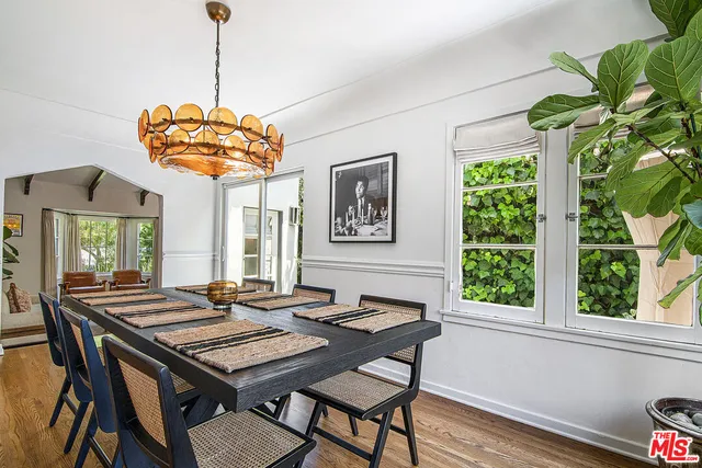 a kitchen with stainless steel appliances granite countertop a refrigerator a sink a stove and white cabinets with wooden floor