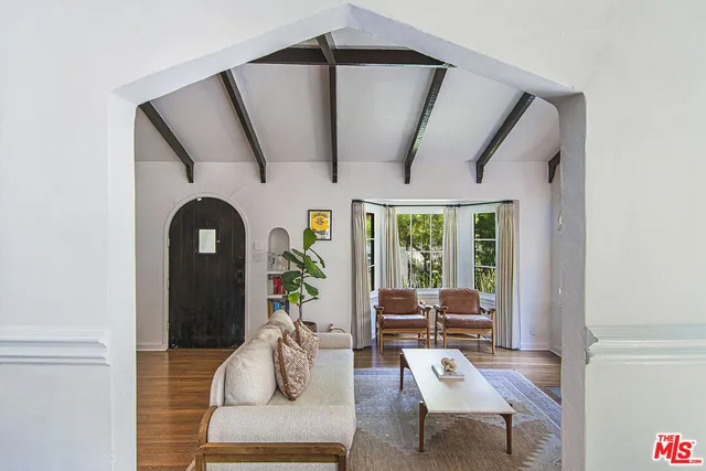 a dining room with furniture potted plants and wooden floor