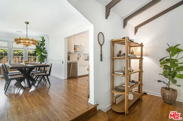 a dining room with furniture a chandelier and wooden floor