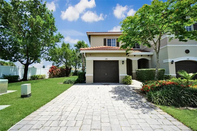 a front view of a house with a yard and trees