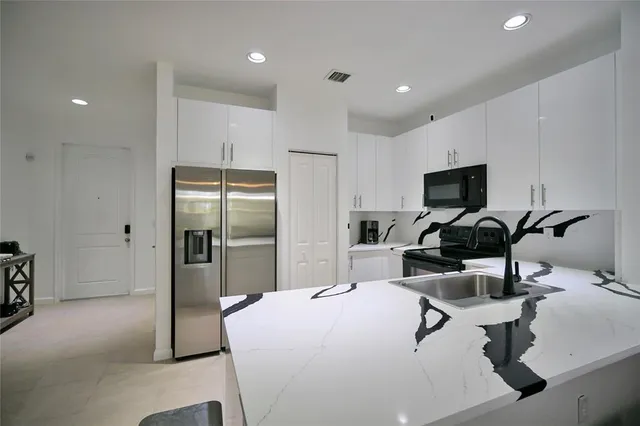 a kitchen with a refrigerator and a sink