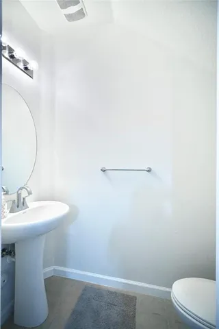 a bathroom with a sink a toilet and mirror