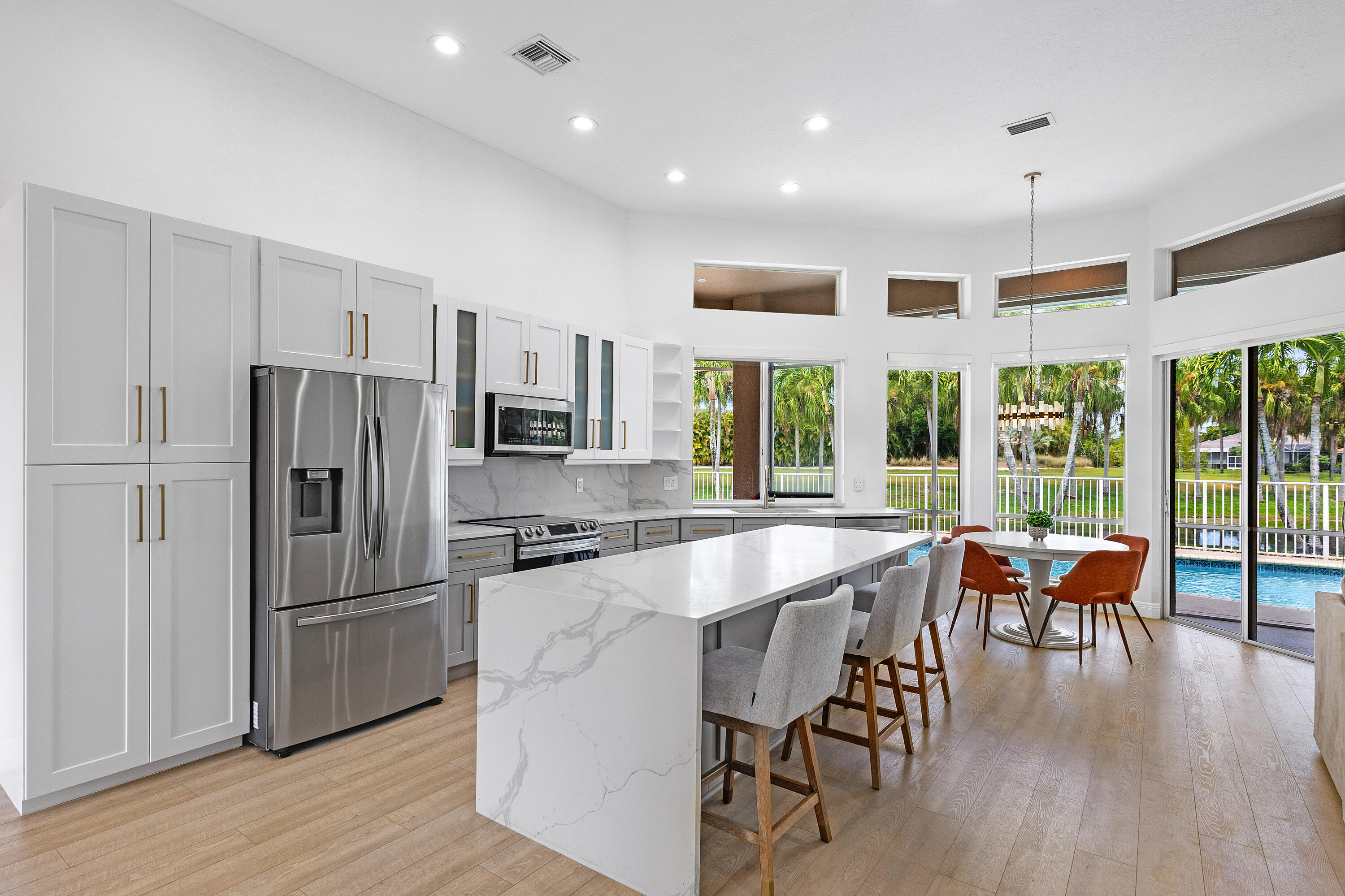 a kitchen with granite countertop a table chairs stainless steel appliances and wooden floor