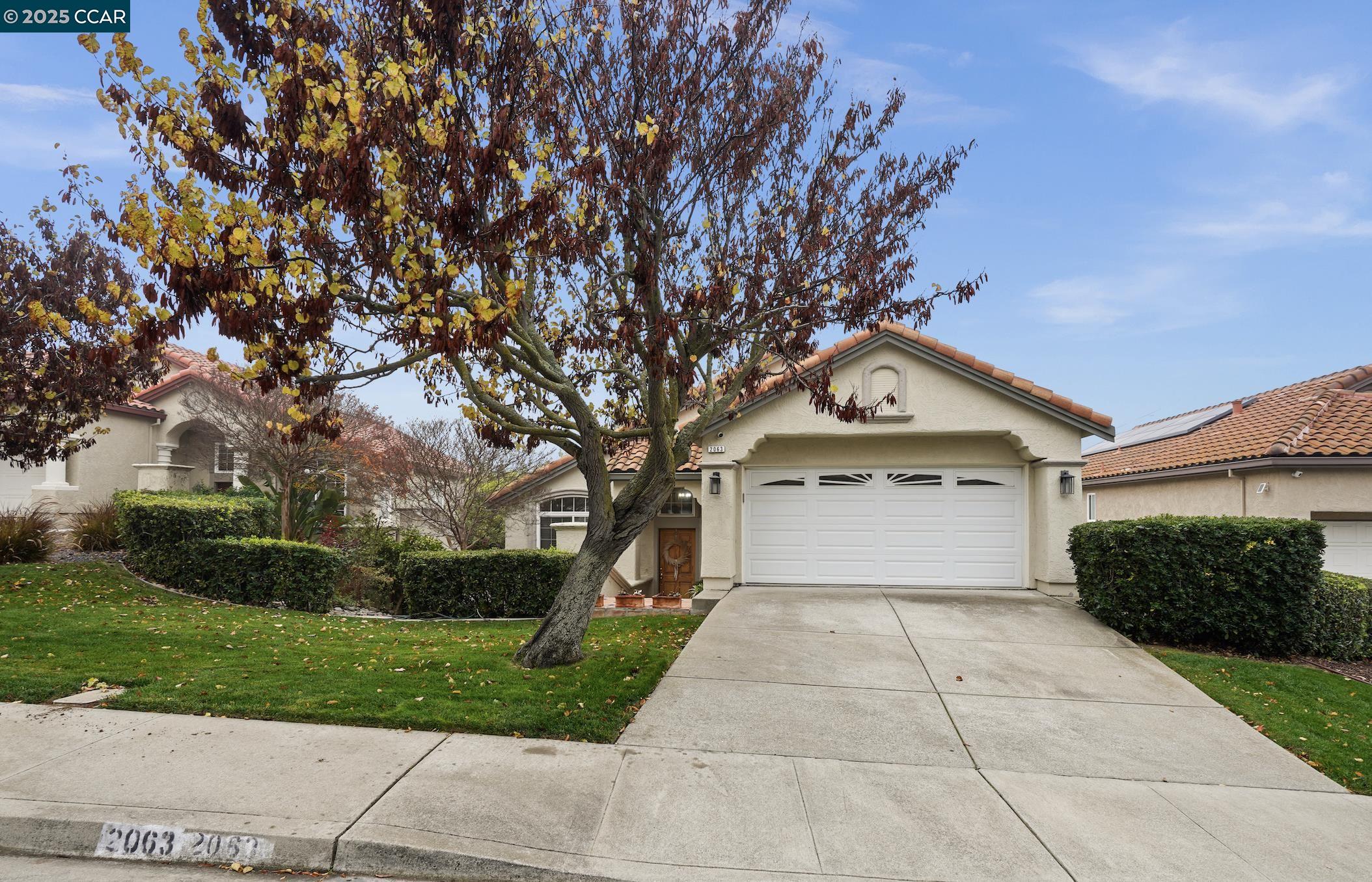 2063 Bluerock Court Concord, CA 94521 - Photo 2 of 38 a front view of a house with a yard and garage