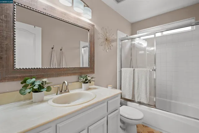 a bathroom with a sink toilet mirror and shower